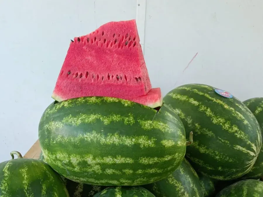 Angurie con l'etichetta Biemme in un bins di legno, una tagliata a spicchio